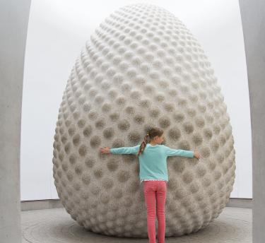 Girl hugging Seed sculpture